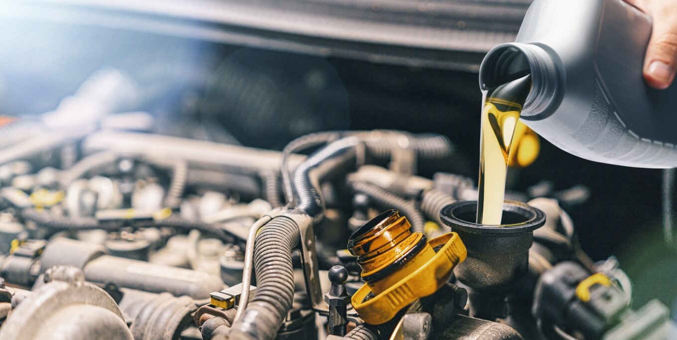 image of oil from 1 quart oil bottle being poured into engine